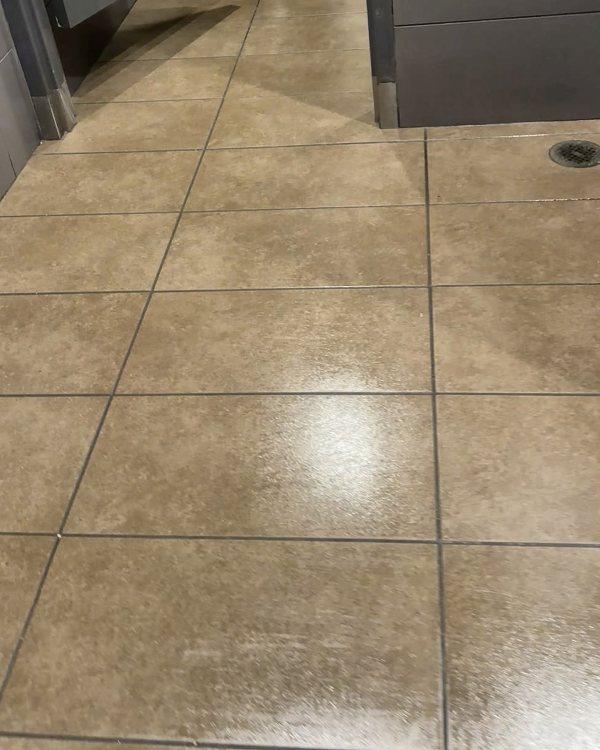 Freshly mopped restroom tile floor with a clean shine
